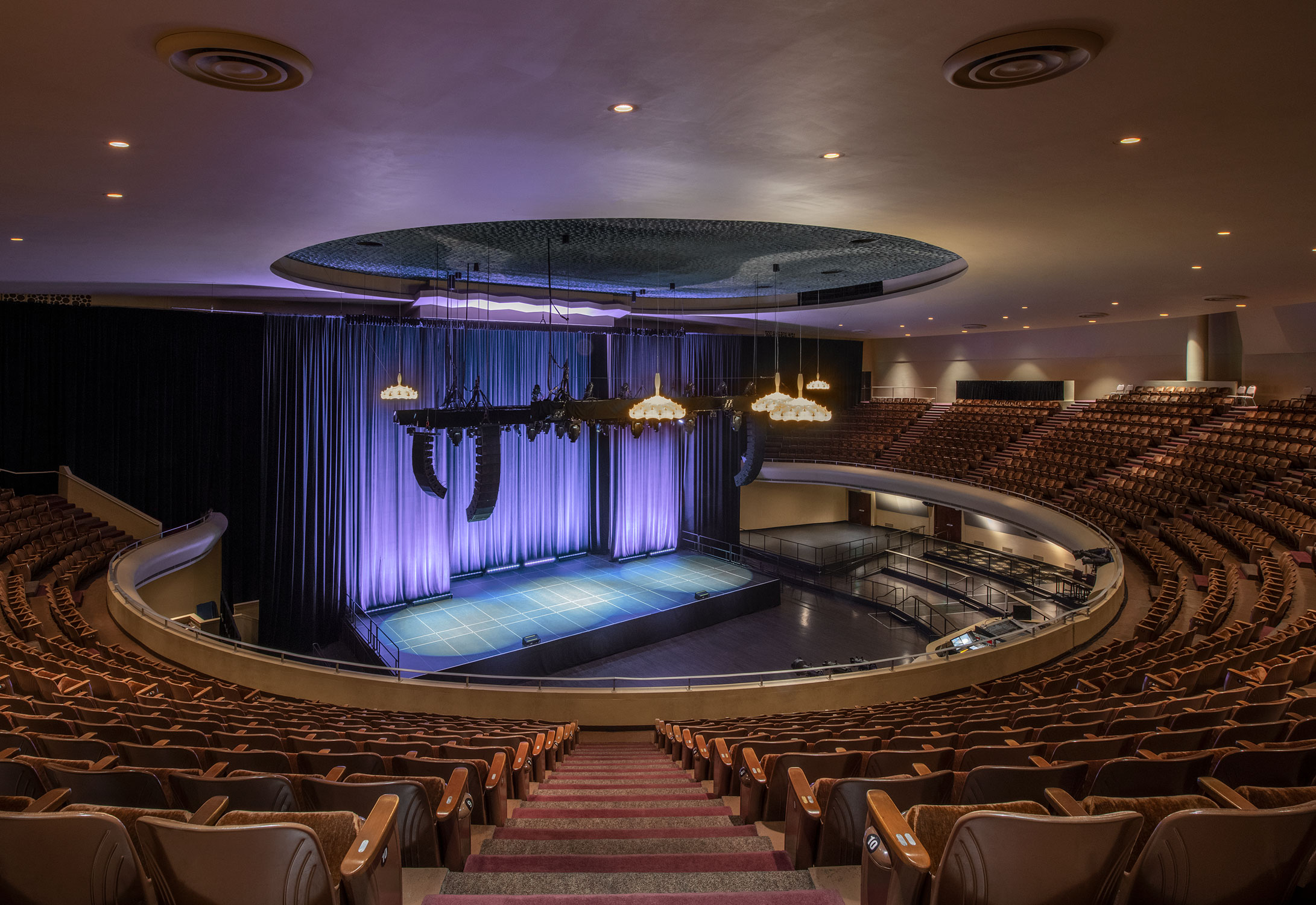 Interior of The Masonic auditorium in San Francisco featuring tiered seating and a large stage illuminated with purple lighting.